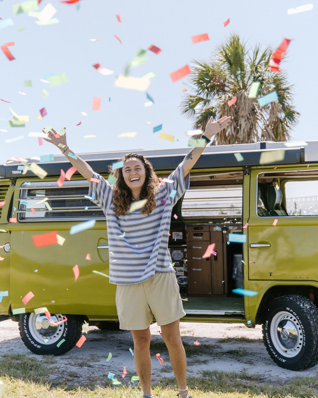 VanLife giveaway 1976 Volkswagen Van Winner Vic H celebrating her win next to her green van.