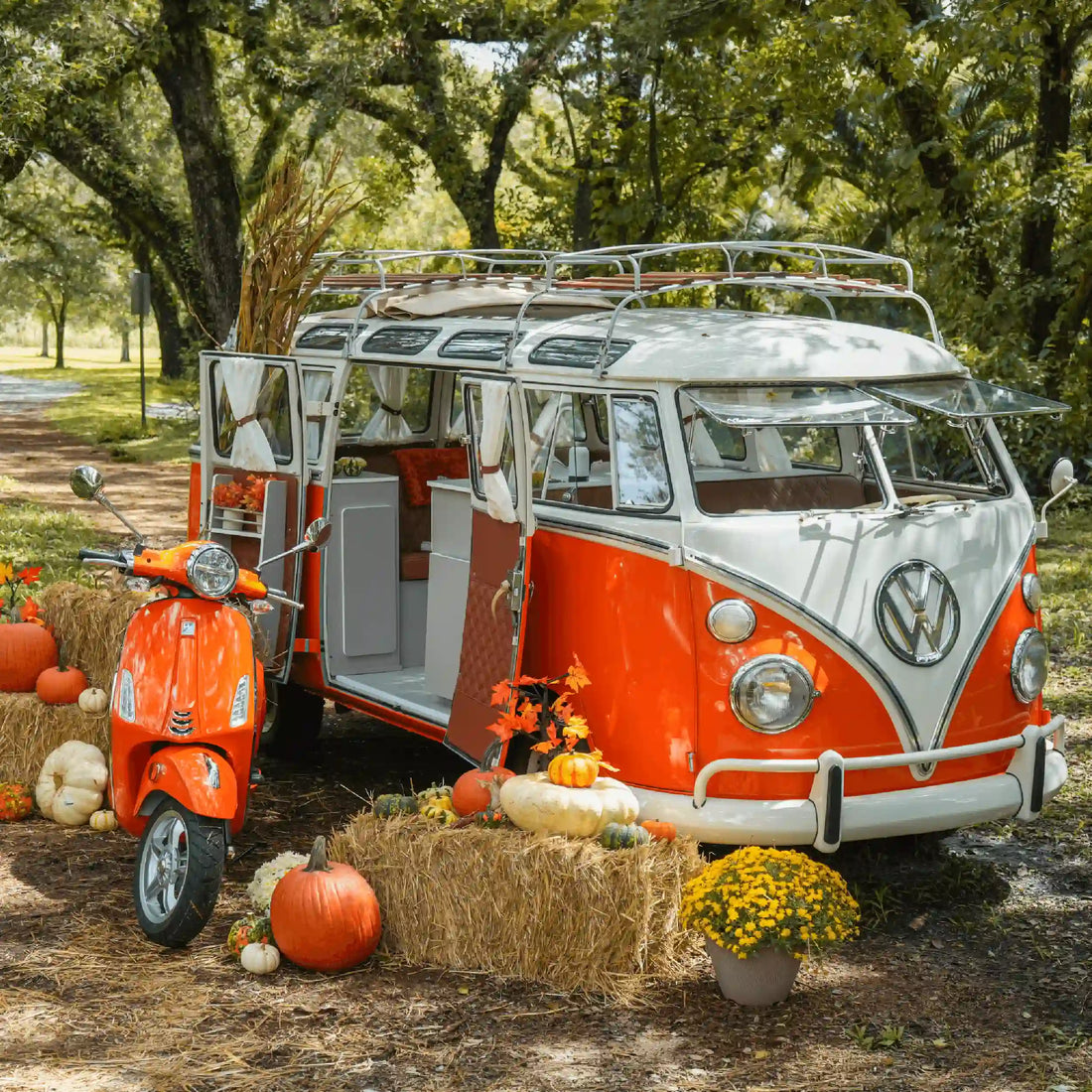 The orange VW Bus camper with the matching orange Vespa, parked among hay bales and pumpkins
