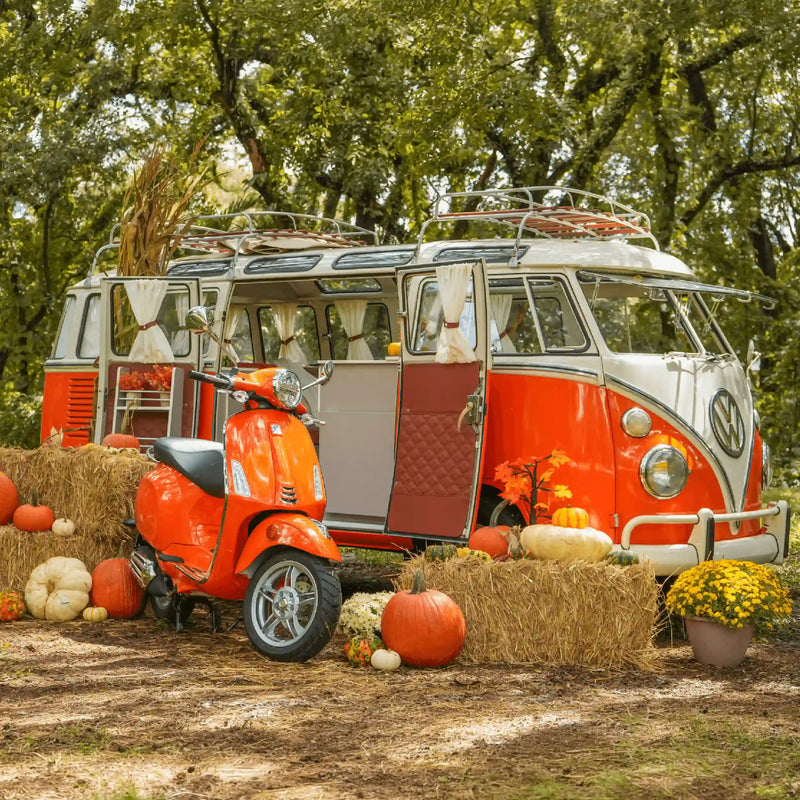 Side view of the orange prize Vespa in front of the open Bus, with hay bales and pumpkins around it