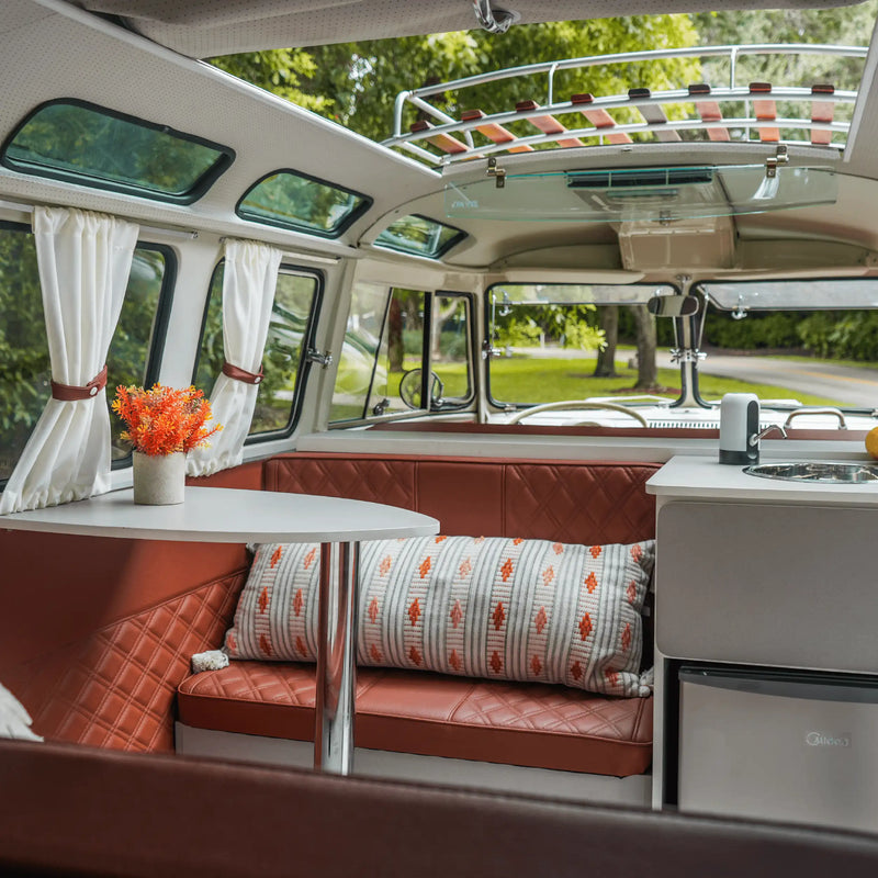Inside the prize Bus with cushioned seating, a table and curtains