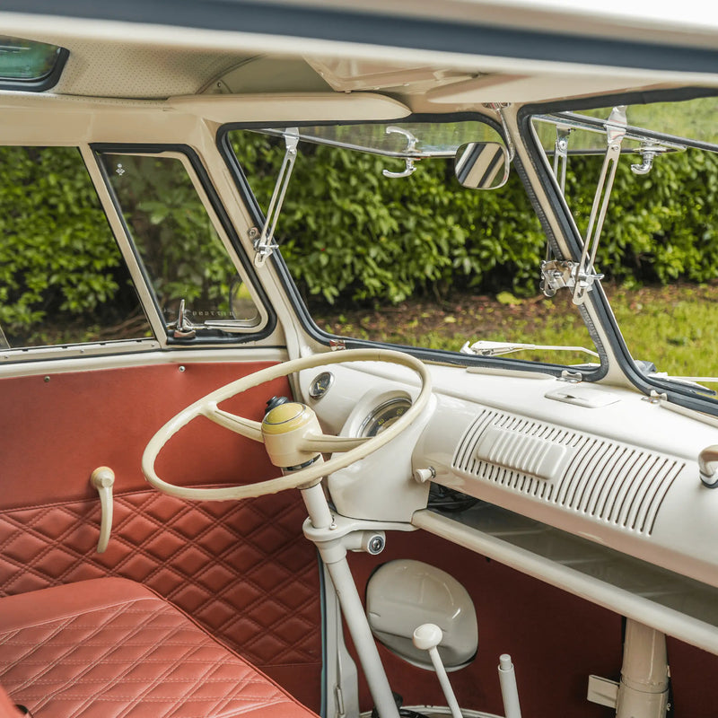The prize Bus cab with a cream steering wheel, classic VW dashboard and a rust-orange diamond-stitched seat
