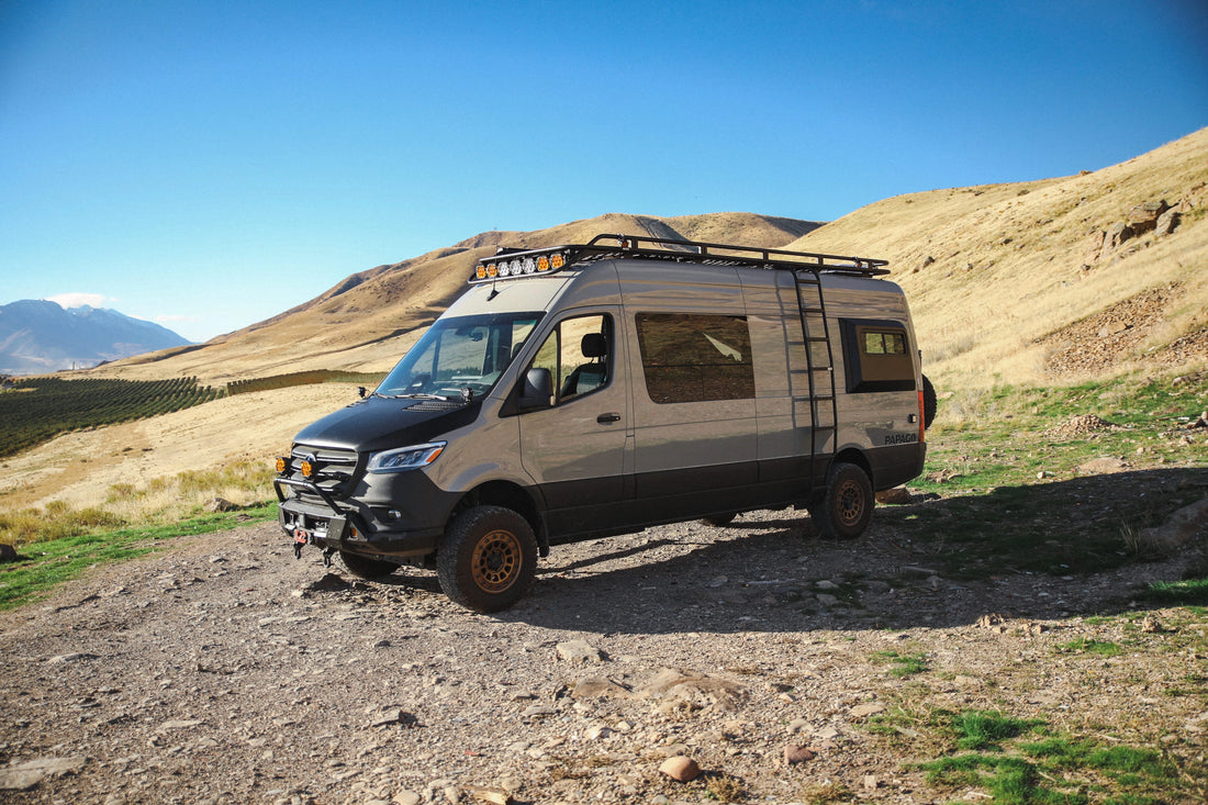 Van life Mercedes Benz Sprinter van parked on dirt road on a mountain side.